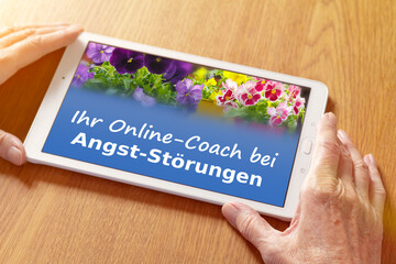 Teletherapy concept: hands with a counseling app on a tablet pc, translation of german text: online coaching for anxiety disorders. - obrazy, fototapety, plakaty