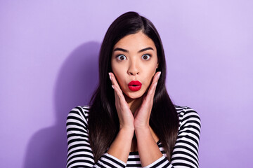 Photo of excited pretty young woman dressed striped outfit arms cheeks big eyes isolated violet color background