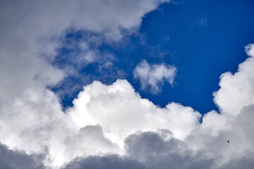 Dramatic thunderclouds float across the blue sky