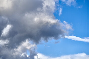 Dramatic thunderclouds float across the blue sky