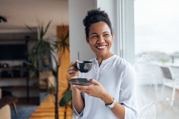 Happy black woman, enjoying in her cup of tea.