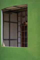 The unfinished interior wall structure in window frames on curve green concrete wall in vertical frame