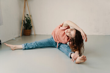 Young woman doing wide open splits with side stretch exercise