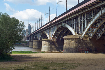 Fototapeta premium Beach under the Poniatowski Bridge in Warsaw (Poniatowka). Panorama of the city beach on the Vistula river