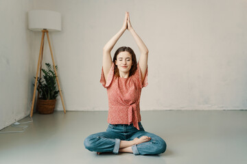 Young woman sitting in the lotus pose meditating