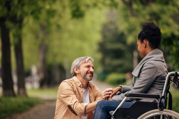 Smiling people, disabled woman enjoying outdoor with her husband.