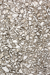 Decorative plaster with small stones is applied to the wall. The pattern and texture of the stone.