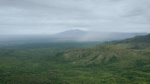 Aerial view of the Omo Valley in Ethiopia, Africa. Landscape of savannah overgrown with trees and surrounded by mountains, peaks and ridges. Drone video of the place from which humanity was born.
