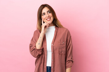 Caucasian woman isolated on pink background thinking an idea while looking up