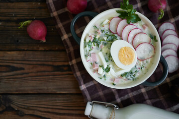 Traditional Russian cold okroshka soup served in a plate with herbs Kefir vegetable soup
