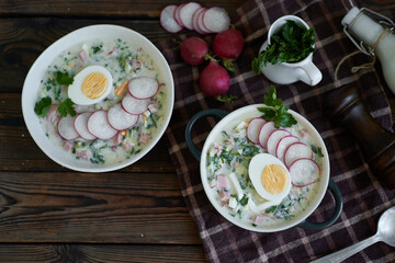 Traditional Russian cold okroshka soup served in a plate with herbs Kefir vegetable soup