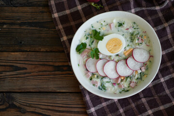 Fototapeta na wymiar Traditional Russian cold okroshka soup served in a plate with herbs Kefir vegetable soup