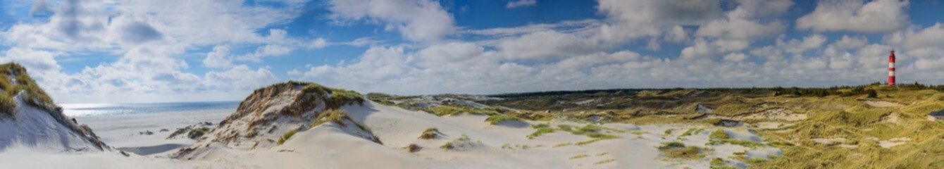 Breathtaking beautiful panorama of coastal landscape at Nort sea and lighthouse on the Isle Amrum, Schleswig-Holstein, Germany. Stunning view from Wadden Sea coastline with sandy beach and wide dunes