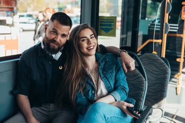 Young beautiful couple in love sitting in a bus and hugging