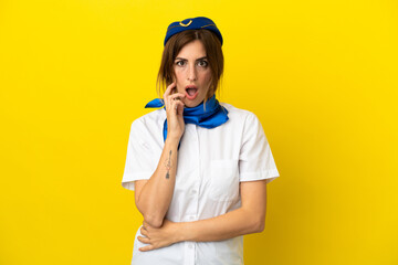 Airplane stewardess woman isolated on yellow background surprised and shocked while looking right