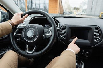 cropped view of man in beige jacket driving car