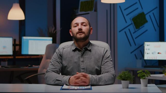 Pov of exhausted businessman discussing with remotely colleague working at financial digital project deadline during videocall conference meeting. Tired entrepreneur working in startup company office