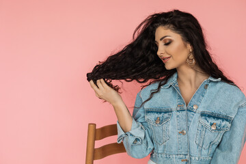 Close-up of a woman stroking her dark natural curly hair. beauty concept