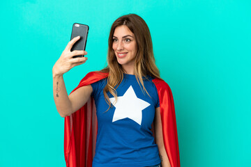 Naklejka premium Super Hero caucasian woman isolated on blue background making a selfie