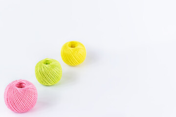 Multicolored skeins of thread for knitting on a white background. Horizontal orientation, copy space. Selective focus.