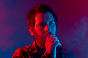 man using electronic cigarette. studio portrait with neon lights. give up smoking.
