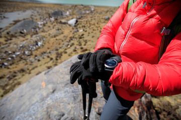 Woman hiker checking the altimeter on sportswatch in winter tibet