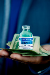 businessman with covid-19 vaccine and dollar notes