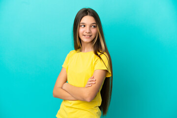 Little girl over isolated blue background with arms crossed and happy