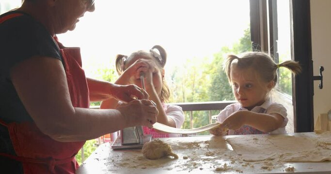 Grandma with two nephew cooking pasta. Old and new generation. Traditional value passed from generation to generation. Family concept , human value. slow motion 
