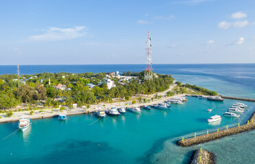 Aerial view of the Maldives island in the Indian ocean with a marina for small ships and a cell...