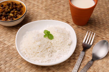 Noolappam , idiyappam rice noodles, string hopper popular steam cooked Kerala breakfast dish hot and spicy chickpea curry , sweet coconut milk Tamil Nadu, India South Indian noolputtu Sri lankan food.