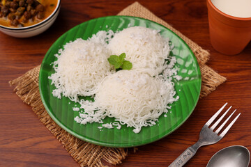 Noolappam , idiyappam rice noodles, string hopper popular steam cooked Kerala breakfast dish hot and spicy chickpea curry , sweet coconut milk Tamil Nadu, India South Indian noolputtu Sri lankan food.