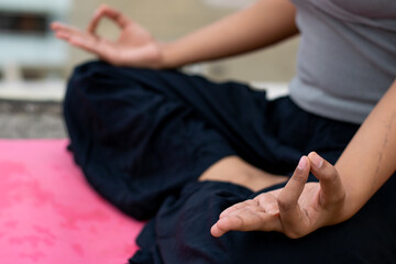 Close up a female hand with fingers in Gyan mudra symbol of wisdom, Indian girl practice yoga sitting in lotus pose