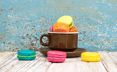 Colorful macarons on vintage pastel background. Macaron or Macaroon is sweet meringue-based confection.