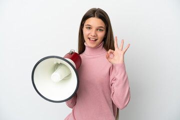 Little girl over isolated white background holding a megaphone and showing ok sign with fingers