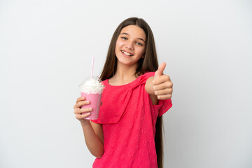 Little girl with strawberry milkshake over isolated white background with thumbs up because something good has happened