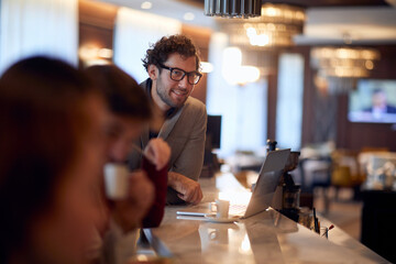 young handsome businessman working from a bar, drinking coffee