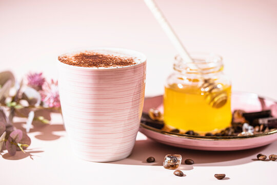 Cappuccino or latte with honey in ceramic dishes. Coffee with milk foam. Coffee, honey, milk and coffee beans.
