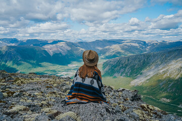 Girl in a hat on the background of a  green mountain valley in Kola Peninsula, Arctic 