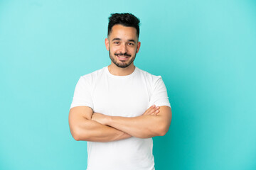 Fototapeta premium Young caucasian man isolated on blue background keeping the arms crossed in frontal position