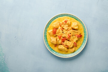 Chicken tikka masala. Traditional of indian cuisine curry and ingredients on dark background. Curry, lime, ginger, cilantro, chili, rice, herbs and spices. Top view with copy space.