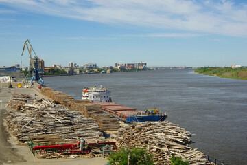 Astrakhan. Russia. 06.20.2021. Loading wood onto a barge on the Volga river.