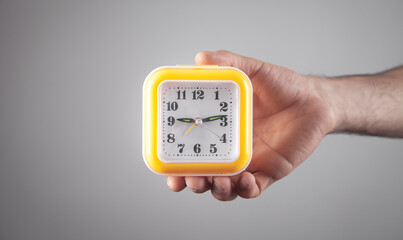 Man holding yellow clock. Business. Time management
