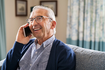 Happy carefree old man talking over phone