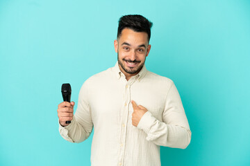 Young caucasian singer man isolated on blue background with surprise facial expression