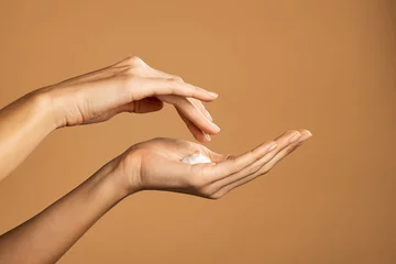 Poster Woman hand applying lotion cream © Rido