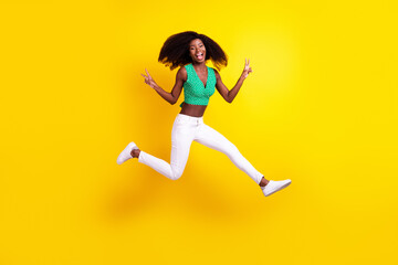 Fototapeta na wymiar Full length body size photo young girl jumping showing v-sign gesture isolated vivid yellow color background