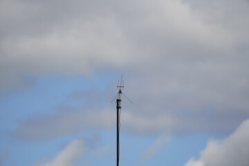 television antenna against blue sky and clouds