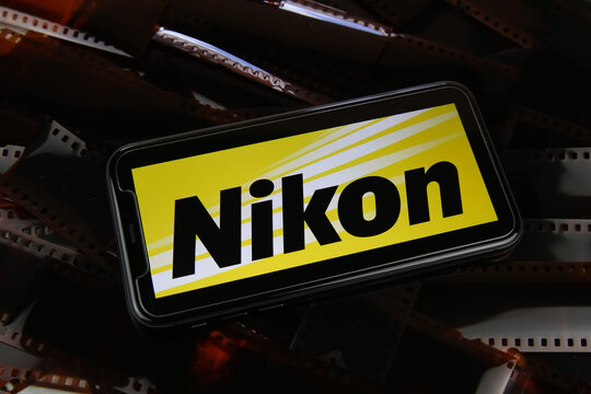 Viersen, Germany - May 9. 2021: Closeup of smartphone with logo lettering of nikon camera on film negative foto strips