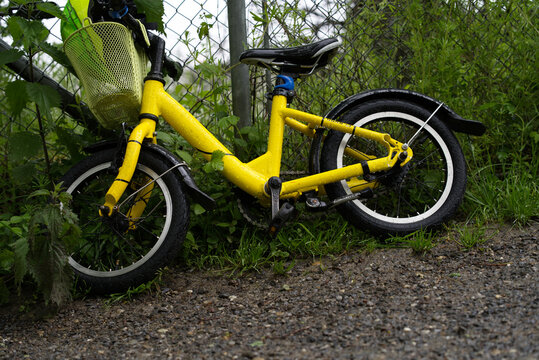 Small yellow children bike at forest border at City of Zurich. Photo taken May 21st, 2021, Zurich, Switzerland.